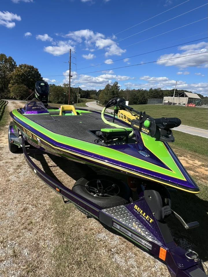 A purple and lime metal-flake Bullet bass boat on its trailer after work at Smokey Mountain Boat Repair